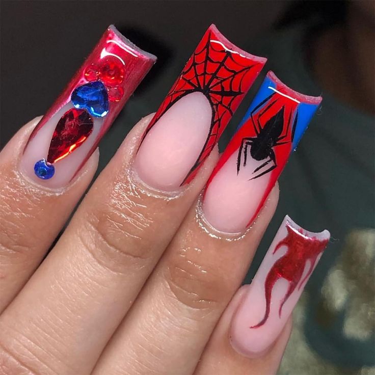 Vibrant Red Nail Art with Intricate Spider Web Patterns and Striking Gem Embellishments.