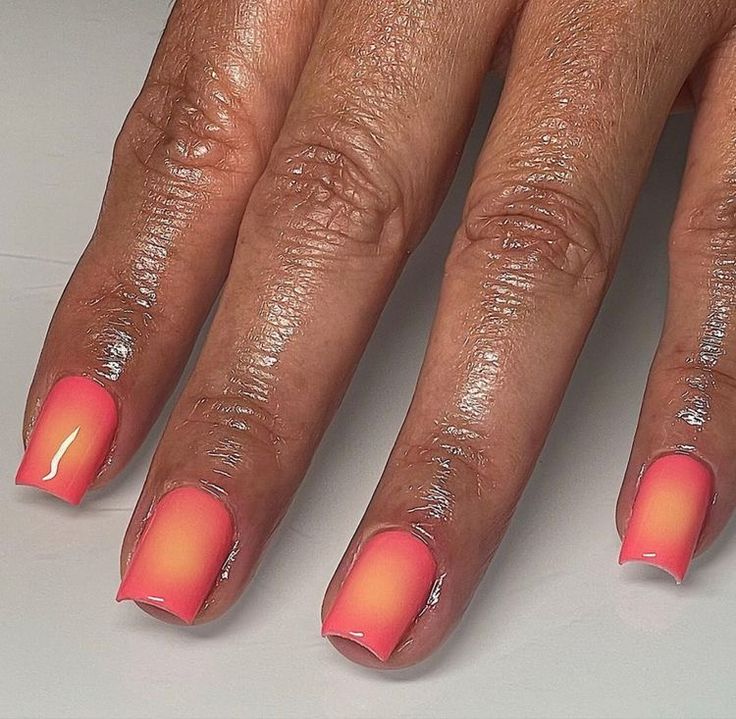 Vibrant Ombre Nail Design: Coral to Bright Pink Gradient for a Playful, Stylish Aesthetic.