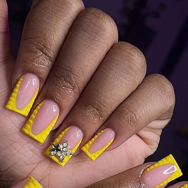 Bold Yellow Nail Design with Textured Tips and Glamorous Star Embellishment.