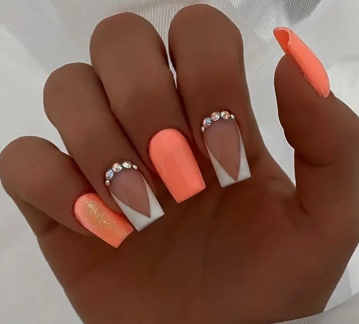 Chic Coral Nail Design with Elegant White Accents and Sparkling Rhinestones.