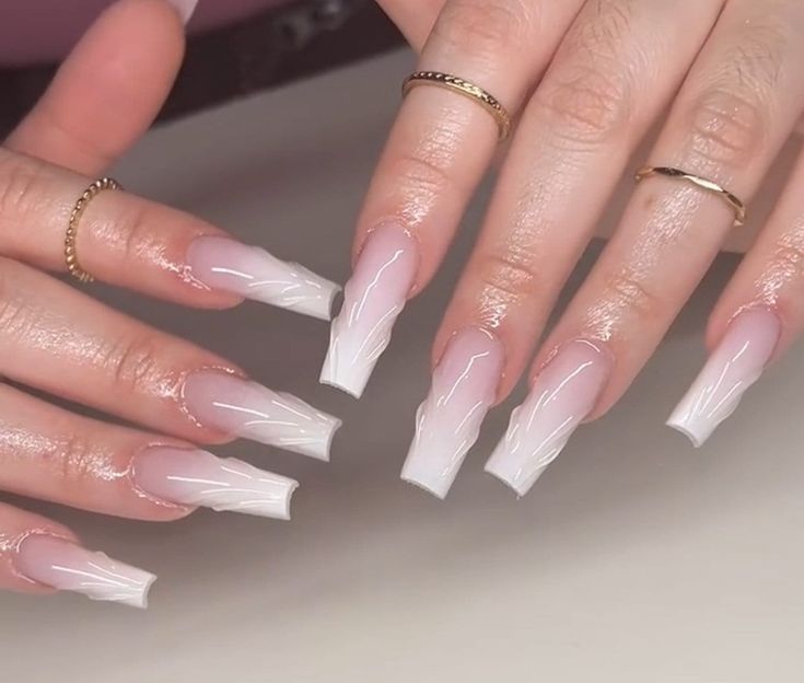 Elegant Ombre Acrylic Nails with Soft Pink Base, Bright White Tips, and Artistic White Line Art Accented by Thin Gold Rings.