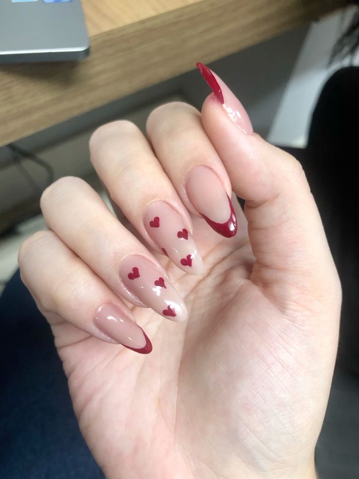 Romantic Heart-Inspired Nail Design: Nude and Deep Red Blend with Playful Accents.