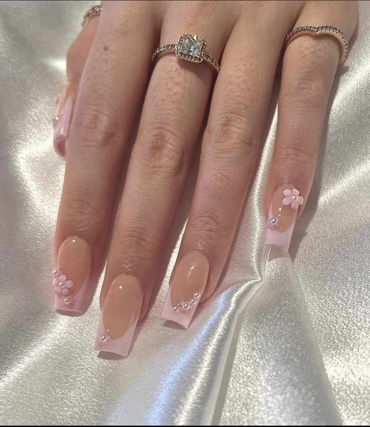 Chic Soft Pink Nail Design with Floral Accents and Gemstones for Any Occasion.