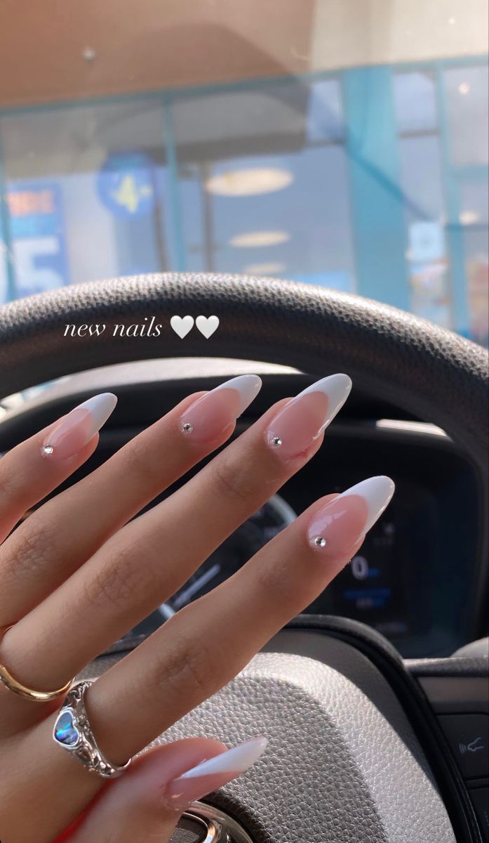 Elegant French Manicure with Almond Tips and Rhinestone Accents.