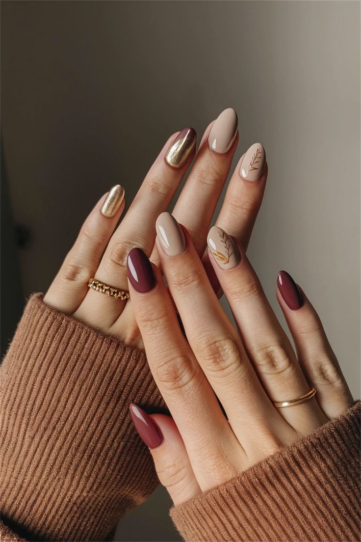 Sophisticated Almond-Shaped Nail Art in Warm Tones with Metallic Accents and Leaf Motifs