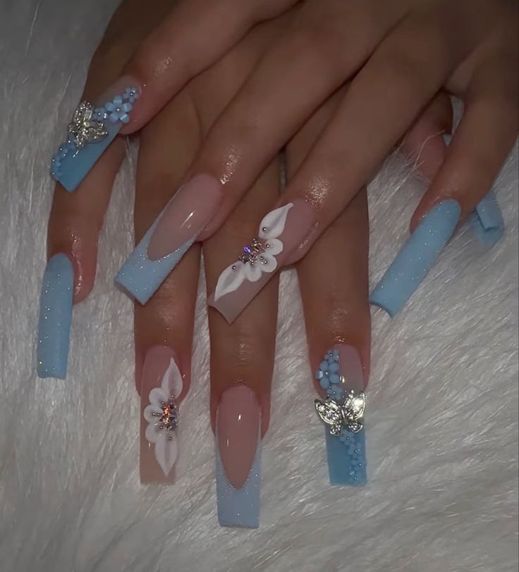 Chic and Playful Nail Design: Soft Blue and Nude Shades with Elegant Floral Patterns and Beads.