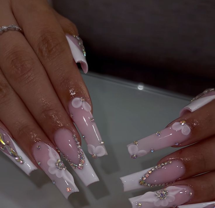 Chic Pink and White Nail Art with Floral Accents and Rhinestones for Glamorous Occasions.