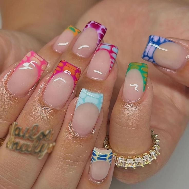 Playful Vibrant Nail Design: Bold Colors and Intricate Patterns with a Modern Twist on French Manicure.