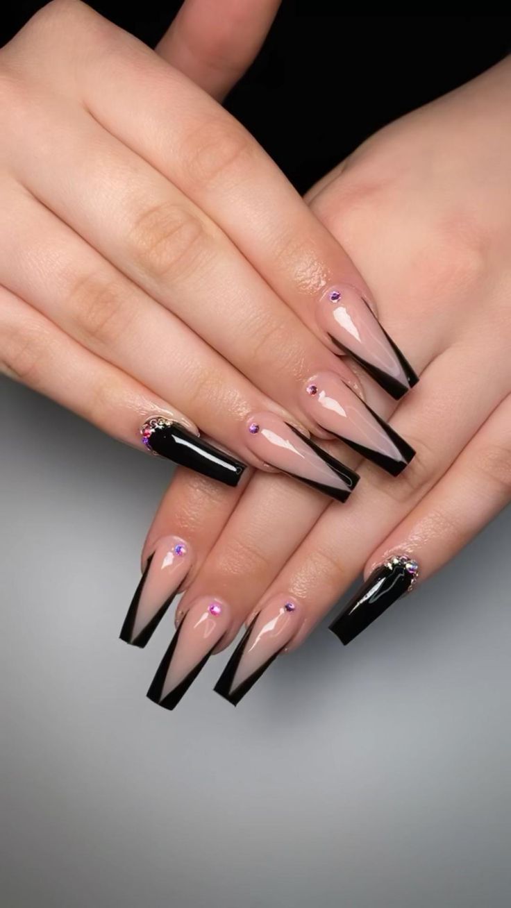 Sophisticated Stiletto Nail Design in Nude and Black with Rhinestone Accents.