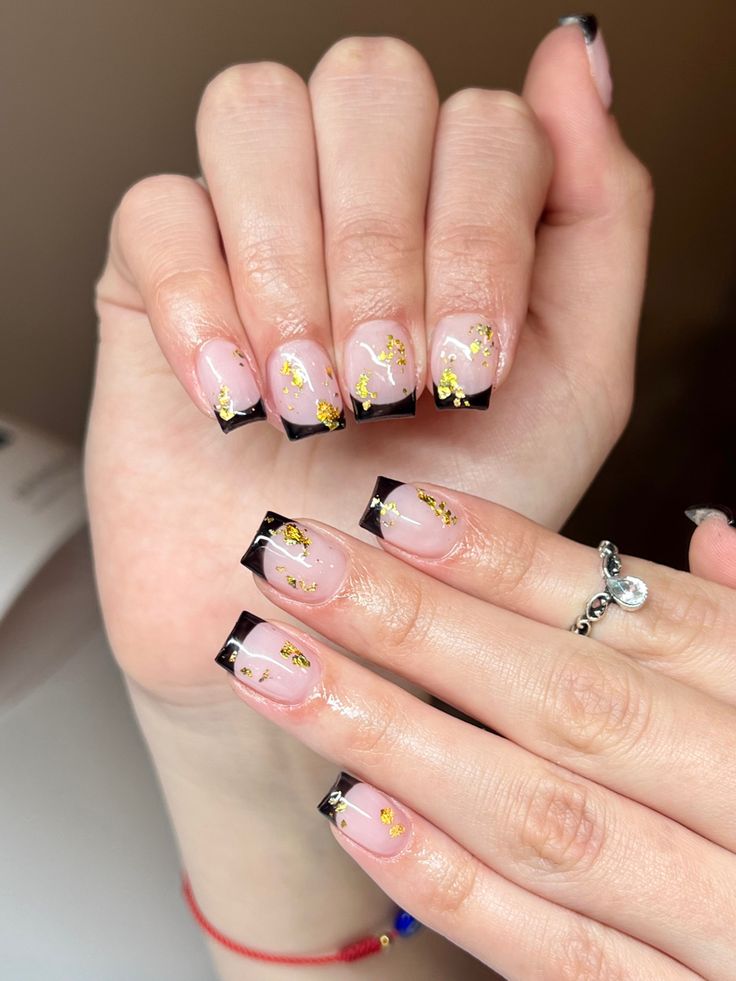 Chic Nude and Black Nail Design with Gold Foil Accents