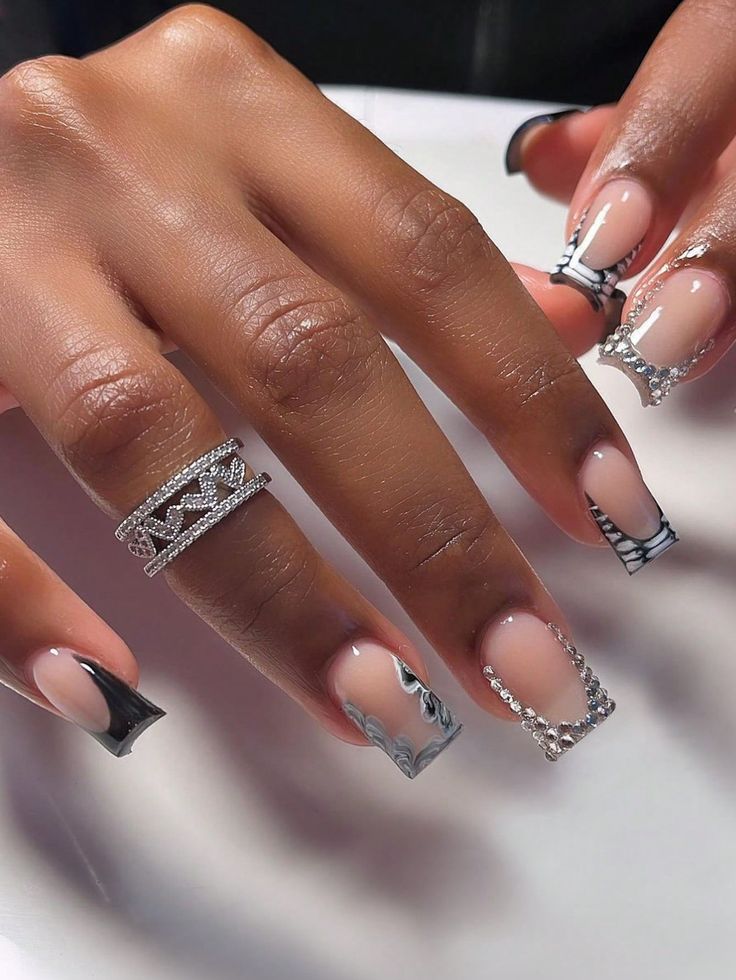 Chic Nail Design with Clear and Black Abstract Patterns Enhanced by Silver Rhinestones for a Modern Glamour.