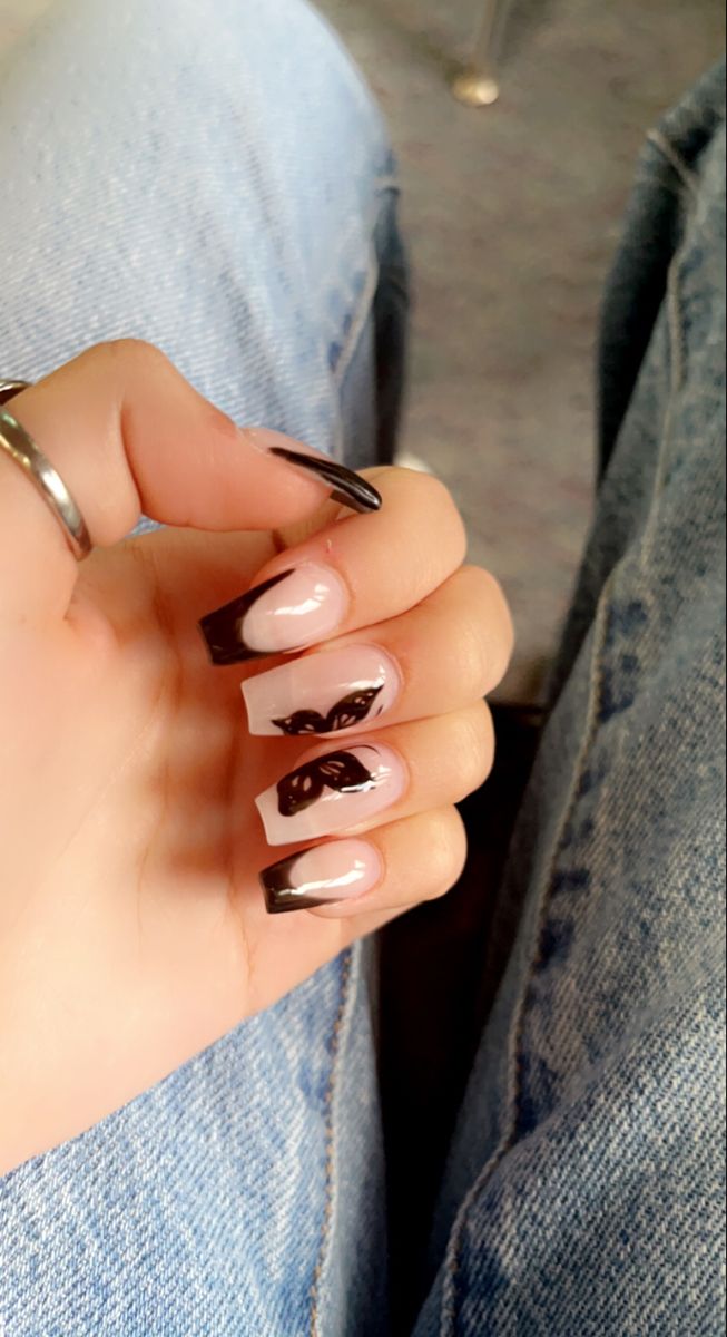 Elegant Nude and Black Nail Design with Striking French Tips and Butterfly Artwork.