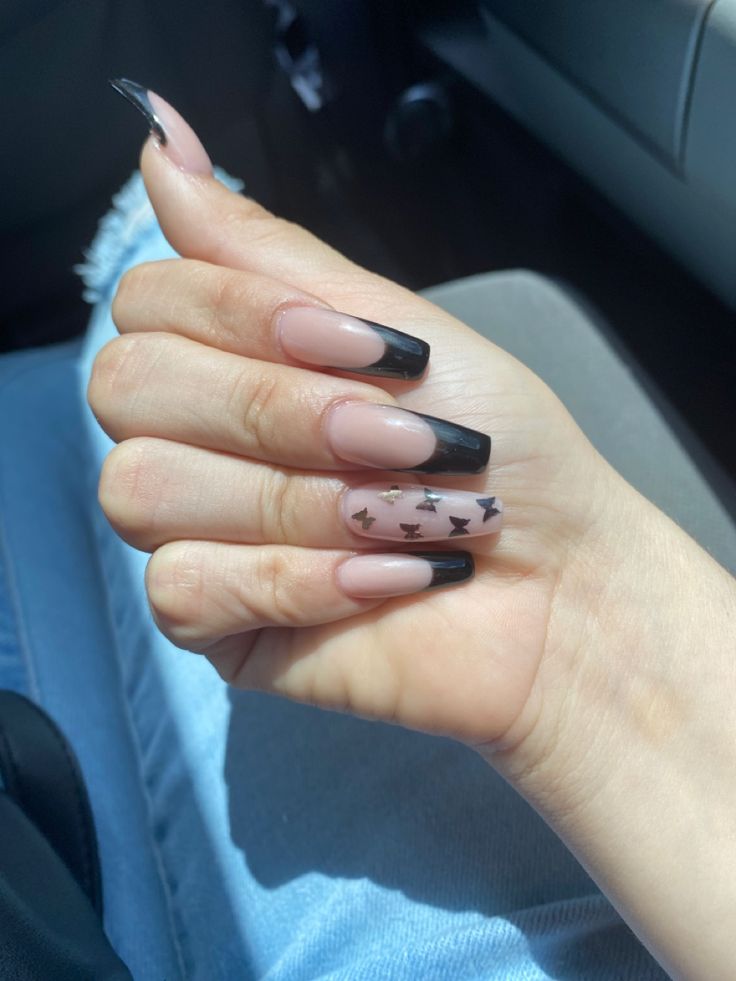 Elegant Acrylic Nails with Soft Nude and Bold Black Tips, Enhanced by Unique Black Triangle Design.