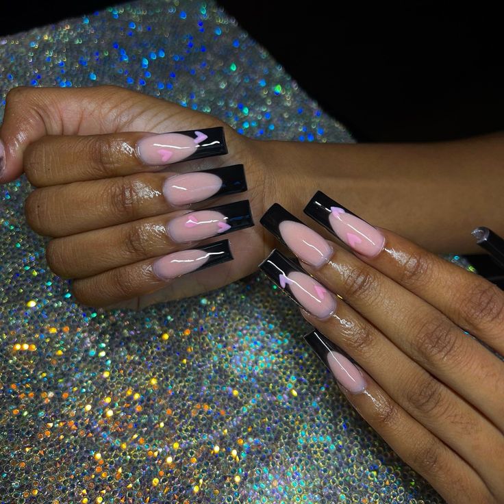 Elegant Nude and Black Long Nails with Glossy Tips and Intricate Detailing.