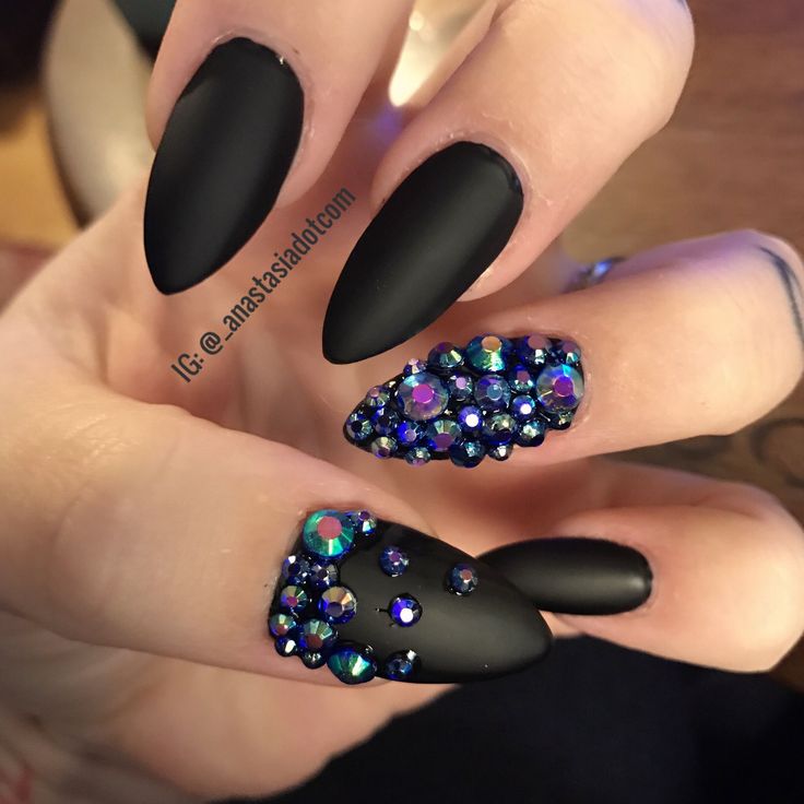 Elegant Matte Black Nails Adorned with Vibrant Rhinestones for a Striking Contrast.