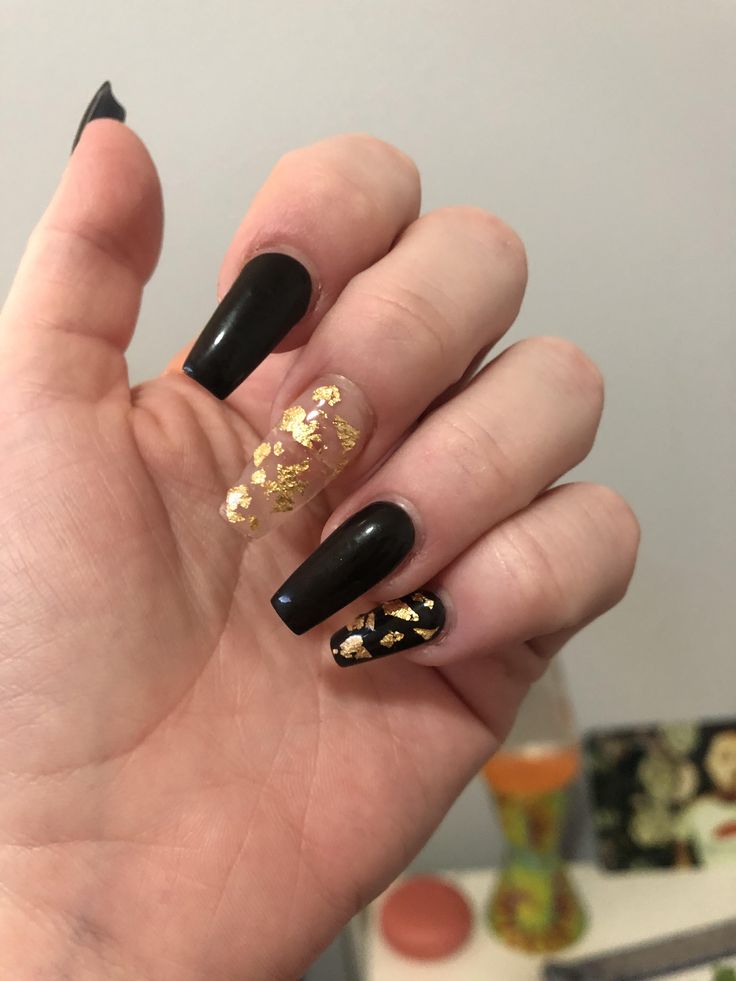 Elegant Nail Design: Glossy Black with Shimmering Gold Accents and Foil Pattern