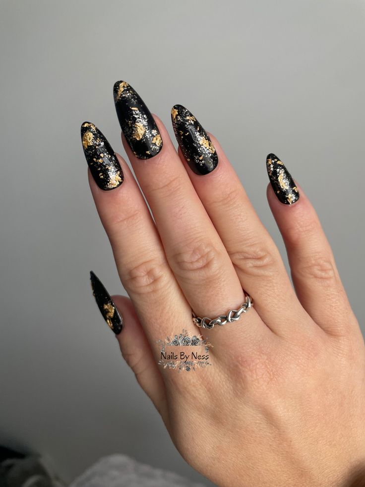 Elegant Black and Gold Stiletto Nail Design for a Bold Fashion Statement.