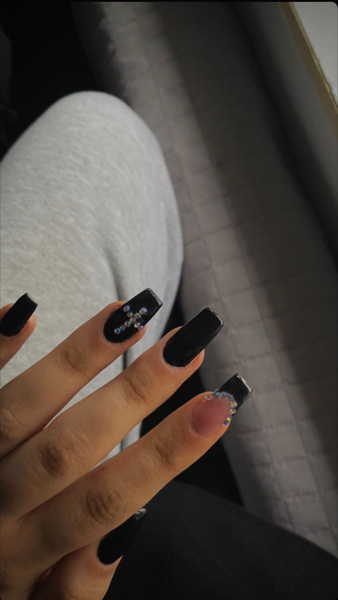 Elegant Black Acrylic Nails with Rhinestones and a Unique Contrasting Accent.