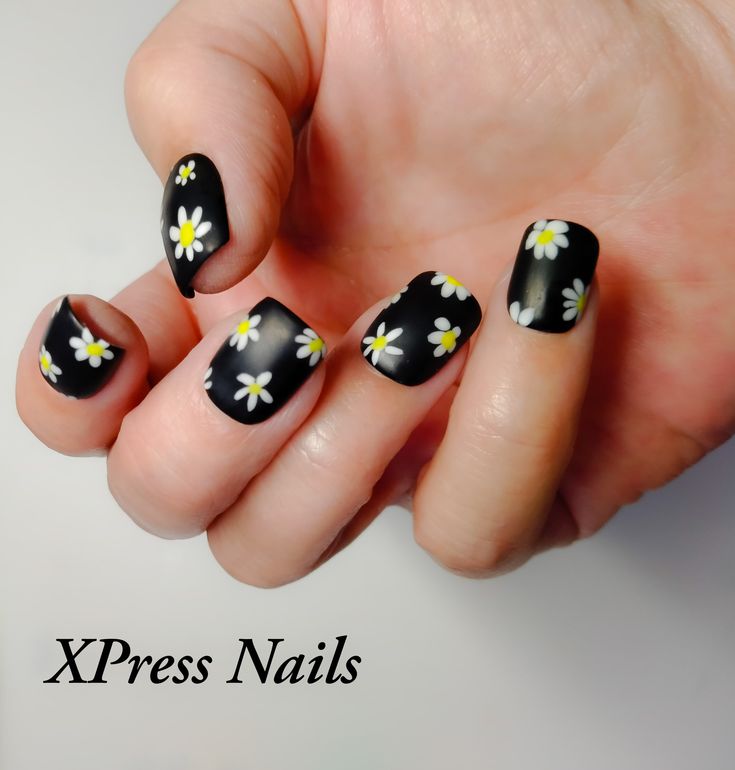 Bold Floral Nail Design with White and Yellow Daisies on a Black Background for a Playful Touch.