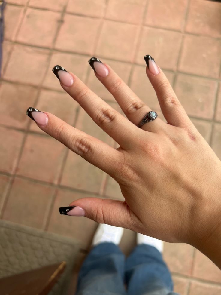 Chic Almond-Shaped Nails with Glossy Black French Tips and Silver Accents.