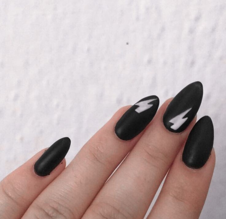 Sleek Matte Black Almond Nails with Striking White Lightning Bolt Accents.