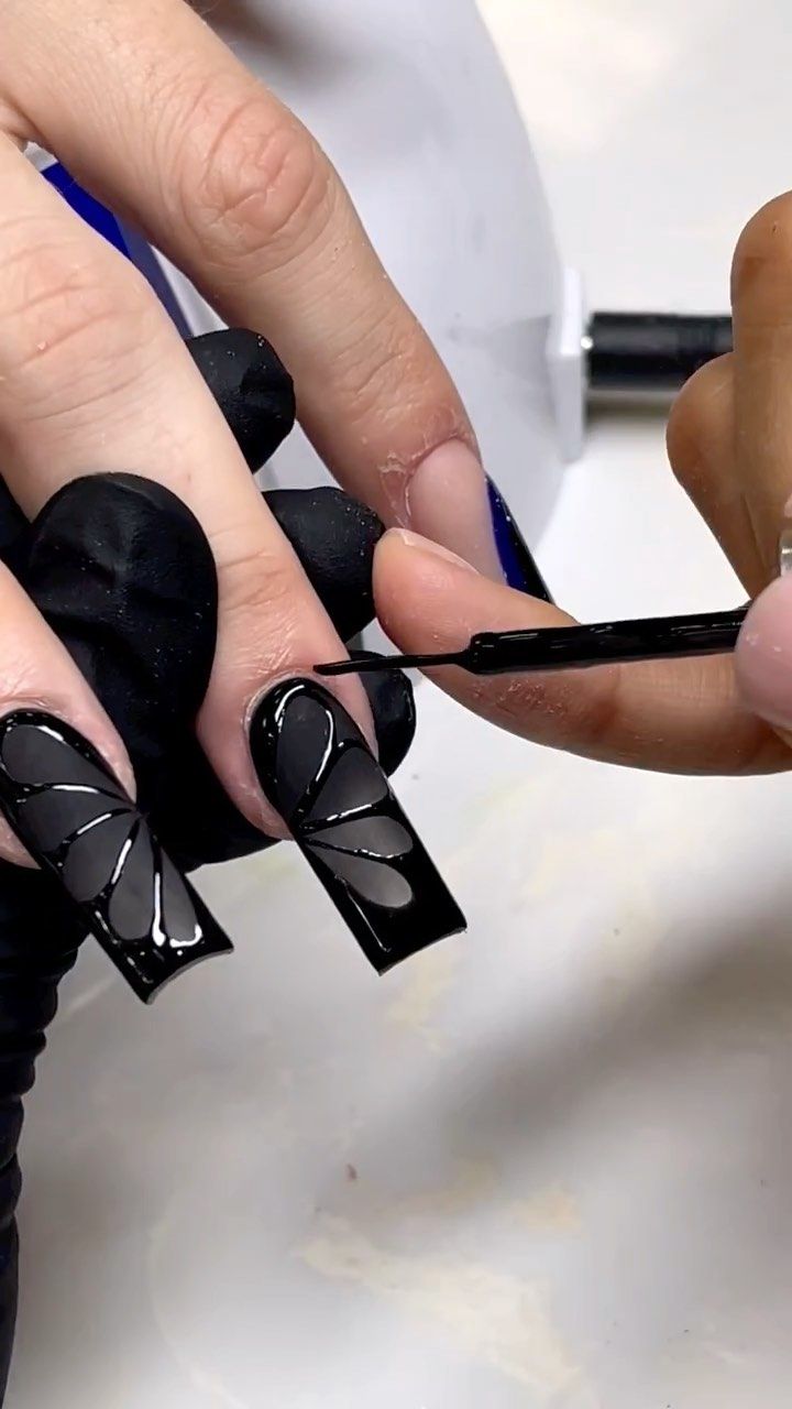 Bold Cut-Out Black Nail Art with Shiny Accents for Fashion-Forward Individuals.