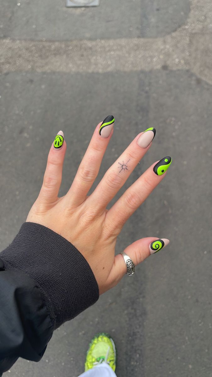 Vibrant Green and Black Nail Design: Whimsical Patterns and Playful Accents for Individuality.