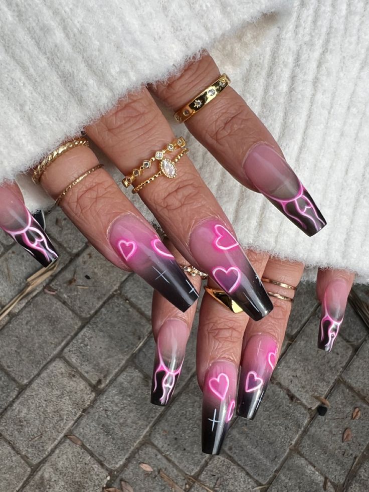 Trendy Coffin-Shaped Nail Design: Soft Pink and Deep Black Gradient with Heart and Lightning Bolt Patterns.