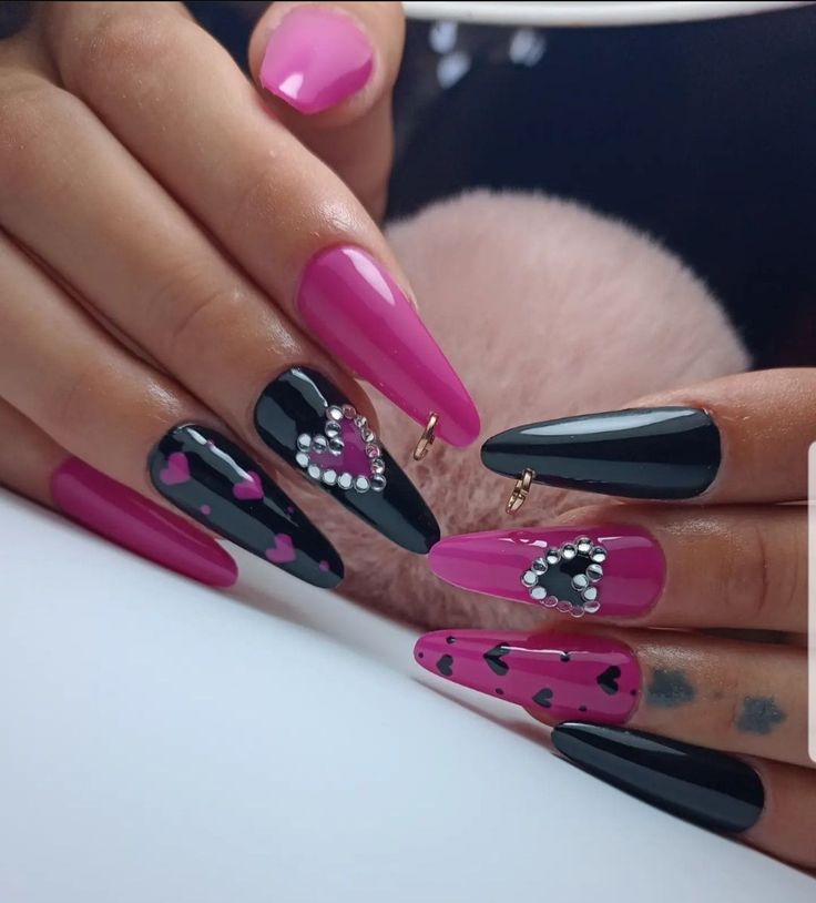 Bold Black and Pink Nail Design with Rhinestones and Heart Motifs for a Fun, Elegant Statement.