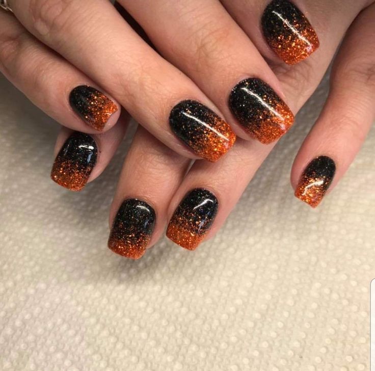 Bold Black and Orange Glitter Gradient Nail Design for Stunning Seasonal Statements.