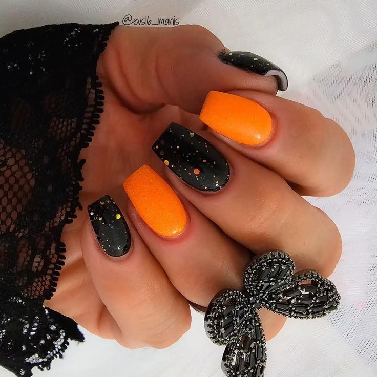 Bold Orange and Black Striking Nail Art with Playful Matte Speckles.