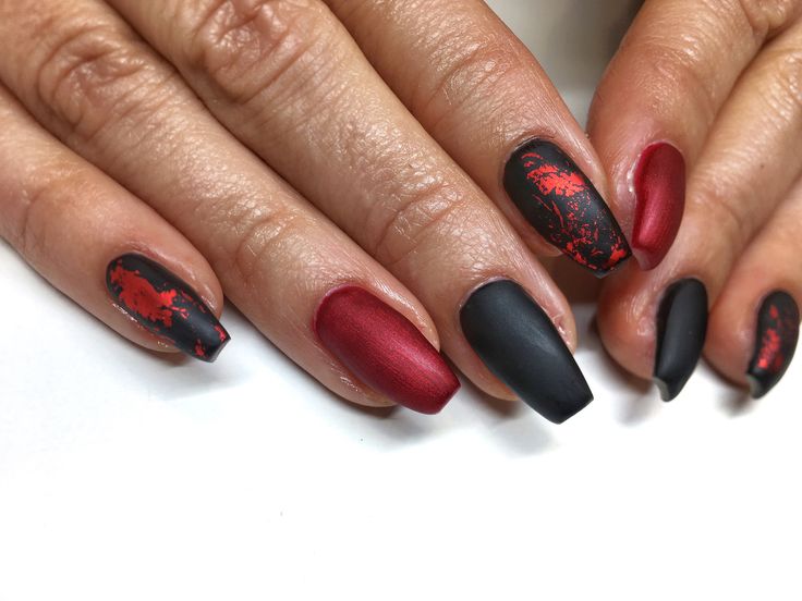 Elegant Nail Design: Bold Matte Black and Deep Red with Floral Accents.