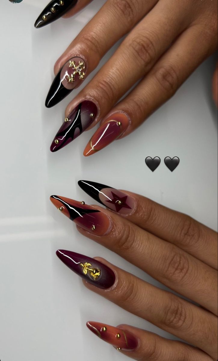 Chic Stiletto Nail Design with Deep Burgundy, Glossy Black, and Metallic Gold Accents.