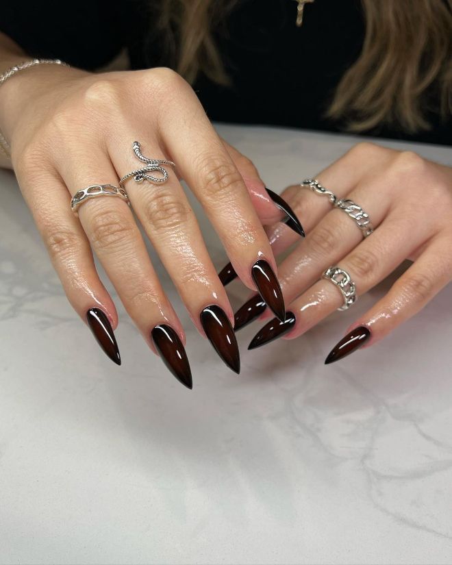 Chic Burgundy Stiletto Nails with White Accents and Silver Rings