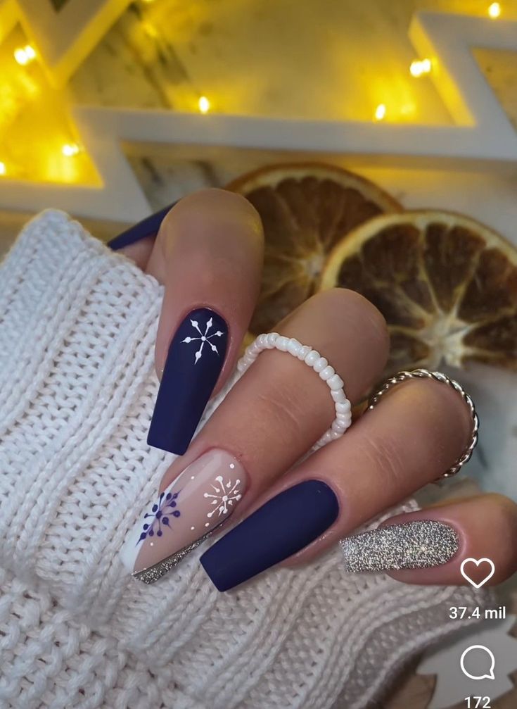 Elegant Winter Nail Design: Deep Navy, Sparkling Silver, and Festive Snowflake Patterns.