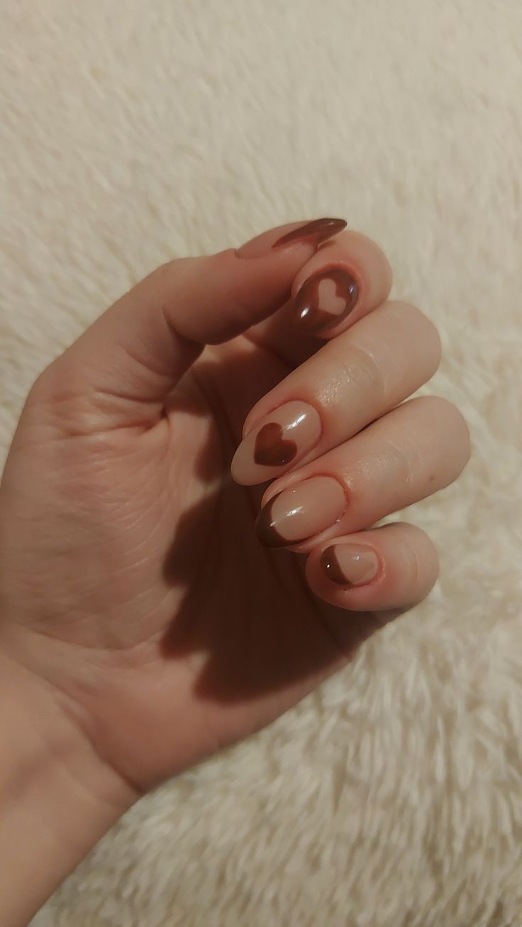 Charming Romantic Aesthetic: Playful Brown Nail Design with Heart Motifs and Trendy Twists.