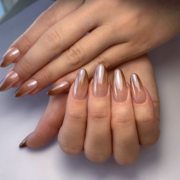 Chic Almond-Shaped Nails: A Stylish Blend of Nude and Brown Tones with a Glossy Finish.