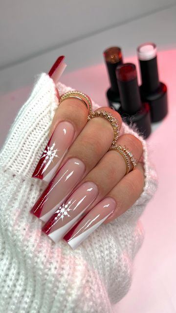 Festive Elegance: Nude and Bold Red Nail Design with Snowflake Details for Winter Celebrations.