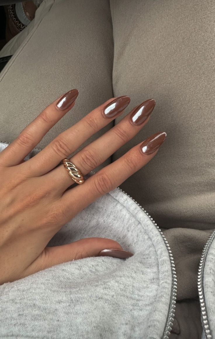 Chic Almond-Shaped Brown Nails with Reflective Tips and Twisted Gold Ring.