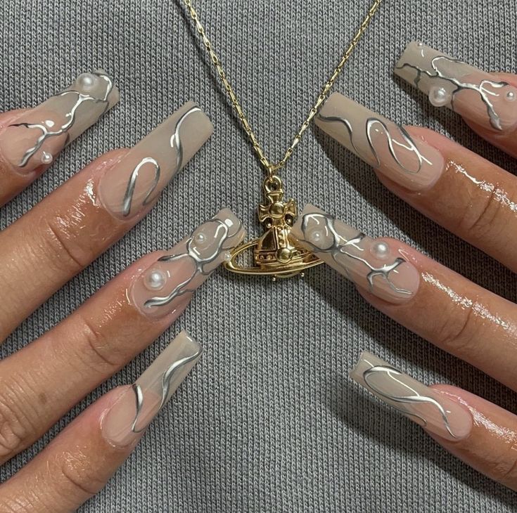 Chic Ombre Nail Art with Creamy Nude Base, Black Swirls, and Pearl Accents.