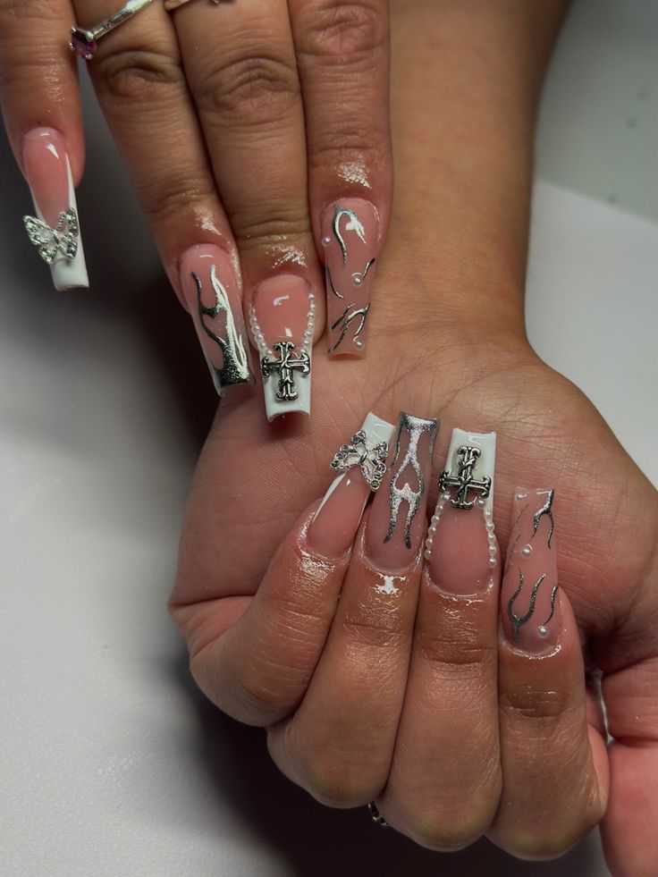 Elegant Pink and White Nail Design with Silver Accents and Decorative Patterns.