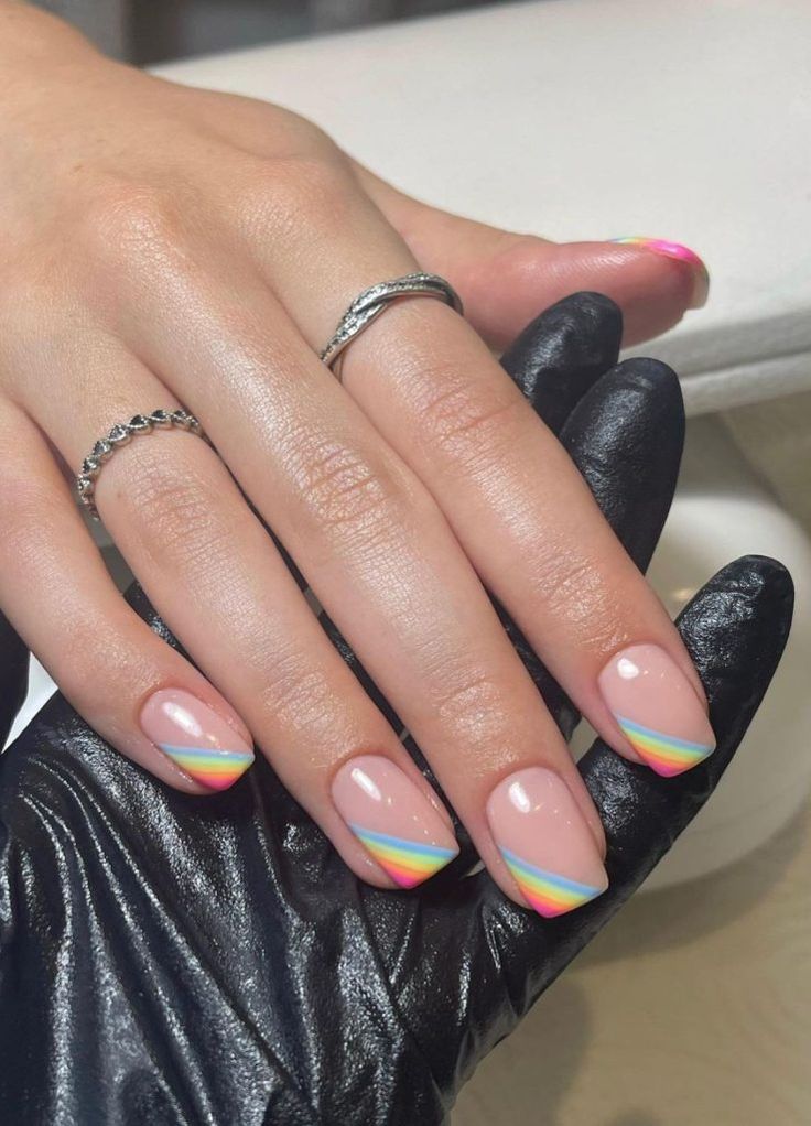 Chic Soft Pink Nail Design with Vibrant Rainbow Tips for a Playful Elegance.