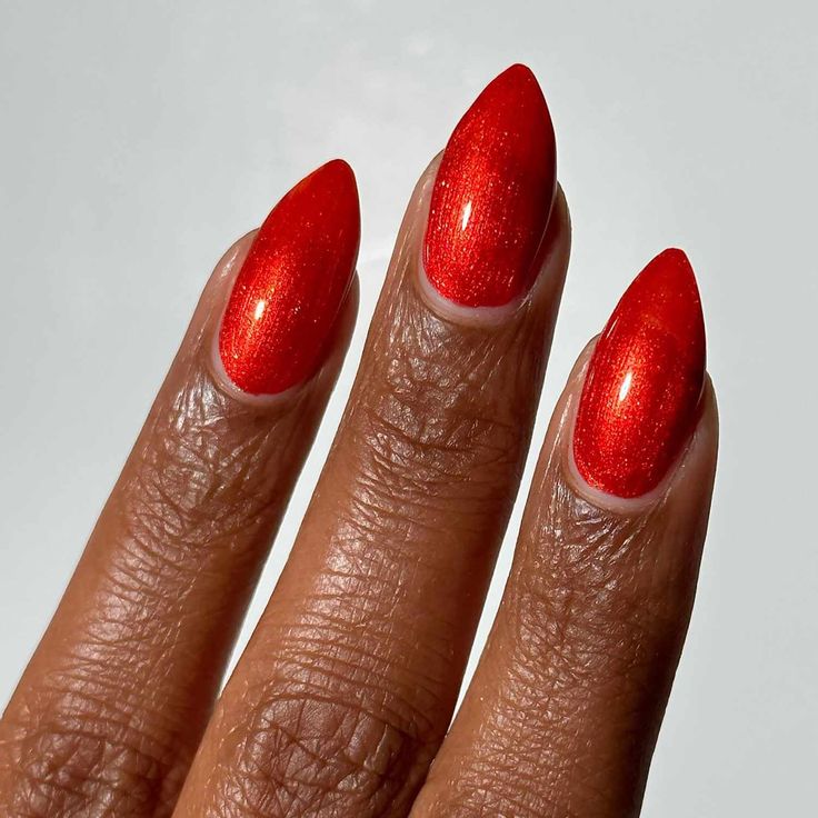 Shimmering Vibrant Red Stiletto Nails: A Glamorous Touch for Any Occasion.