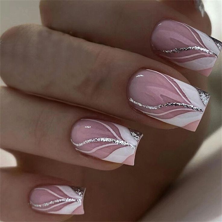 Sophisticated Nail Design: Soft Pink Base with Swirling White Accents and Delicate Silver Sparkle.