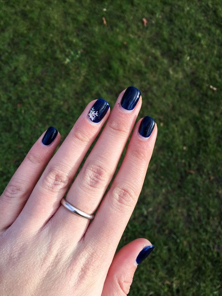 Sophisticated Winter Nail Design: Deep Navy with Delicate Snowflake Accent