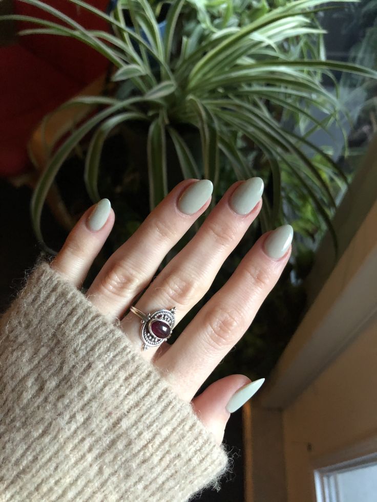 Chic Almond-Shaped Green Matte Nails Enhanced by Sophisticated Silver Ring.