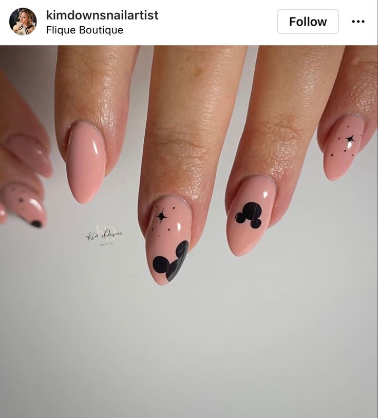 Elegant Nude and Bold Black Nail Design with Artistic Patterns