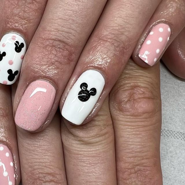 Whimsical Pink and White Nail Designs with Playful Patterns and Glossy Finish.