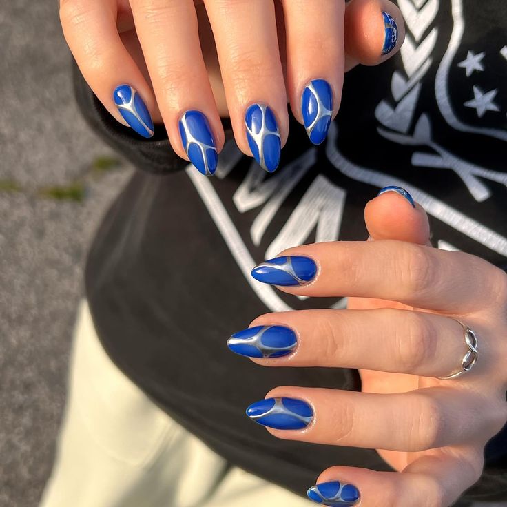 Bold Blue Nail Design with Glossy and Matte Finishes in Artistic Patterns.