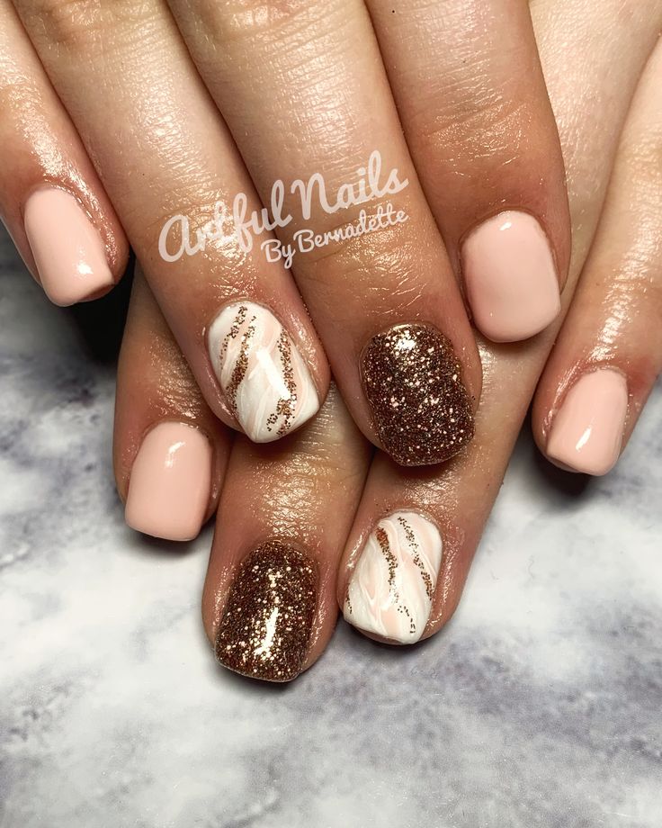 Chic Manicure: Elegant Nude and Gold with Glamorous Glittery Brown and Sophisticated Marble Accents.